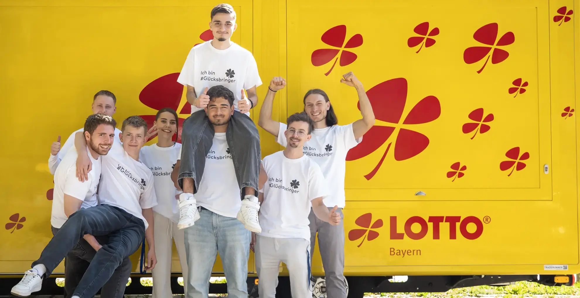 Mitarbeiterin und Mitarbeiter in Shirts mit Aufschrift: Ich bin #glücksbringer. Foto: SLSV