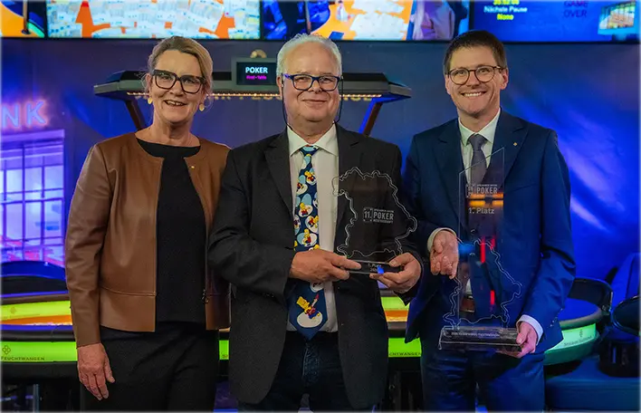 Bayerns Pokermeister 2026 Fisheater am Final Table der 11. Spielbanken Bayern Pokermeisterschaft 2026 in der Spielbank Feuchtwangen (links außen: Claudia Böhm, Abteilungsleitung der Spielbanken Bayern, rechts außen: Thorsten Müller – Direktor der Bayerischen Spielbank Feuchtwangen).